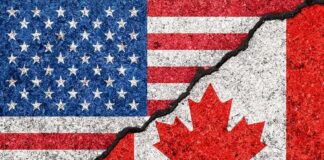 American and Canadian flags separated by a crack