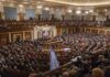 People seated in a large governmental assembly hall