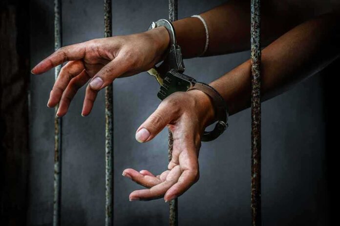 581788483 featured image Hands in handcuffs behind prison bars