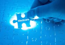 Hand holding Medicare puzzle piece over board