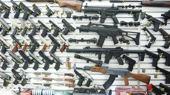 1096565825 featured image Wall display of various firearms in a store.