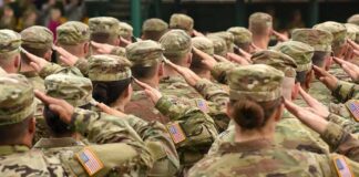 Soldiers in uniform saluting during a ceremony