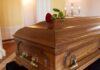 Wooden coffin with red rose on top