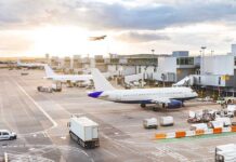 Airport with airplanes runway and terminal at sunset