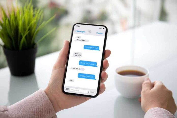 1232266612 featured image Person holding smartphone with text conversation displayed