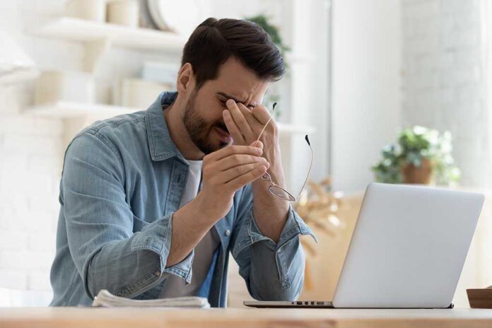 1575539137 featured image Man rubbing eyes while holding glasses near laptop