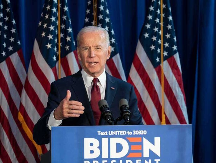 1608793423 featured image Man speaking at podium with American flags behind