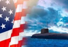 American flag and submarine at sea under a cloudy sky