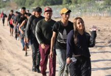 Line of people walking on a dirt road