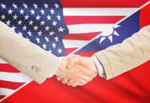 Two people shaking hands with USA Taiwan flags