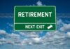 Green road sign reading retirement next exit sky background