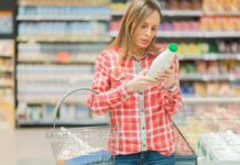 Woman examining a bottle in a grocery store