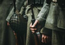 Soldiers in uniform holding rifles and grenades