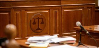 Wooden courtroom desk with papers and a microphone