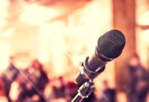 Closeup of microphone with blurred audience background