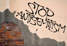 Stop antisemitism graffiti on a worn brick wall