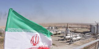 Iranian flag near an industrial gas refinery