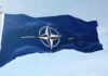 NATO flag waving against blue sky