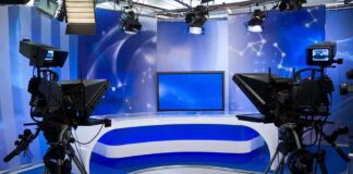 A television studio setup with cameras and a blue backdrop