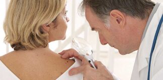 Doctor examining a patient's skin with a magnifying glass