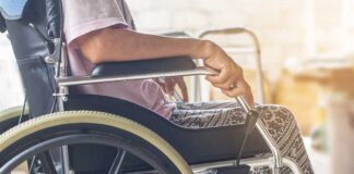 Close-up of a person sitting in a wheelchair with patterned pants