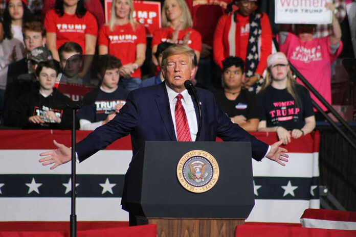 Politician speaking at rally with supporters behind him