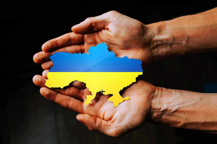 Hands holding Ukraine map with flag design