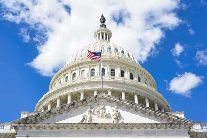 The US Capitol building with an American flag flying in front against a blue sky