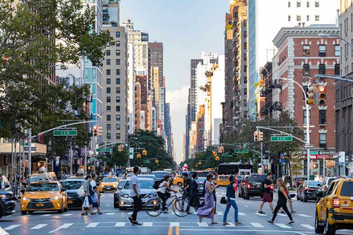 Busy city street with pedestrians cars and tall buildings