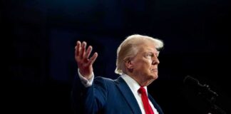 A man in a suit gesturing during a speech