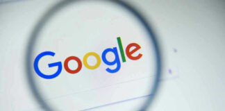 Google logo viewed through a magnifying glass.