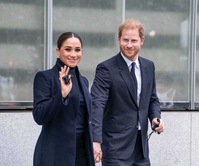 A couple dressed in formal attire smiling and walking hand in hand