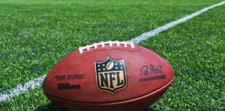 NFL Team’s Plane Drama – Travel Jinx Strikes! An NFL football resting on a green grass field
