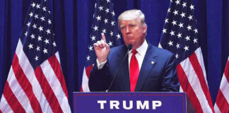 BOMBSHELL: Trump’s NEW Greenland Strategy Man speaking at podium with USA flags behind him.