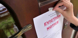 Hollywood CELEBRITY’S SHOCKING Eviction Hand tacking eviction notice on a wooden door.
