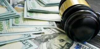 Trump DEMANDS $6.2 Million From Corrupt Prosecutor Gavel and hundred dollar bills on table.