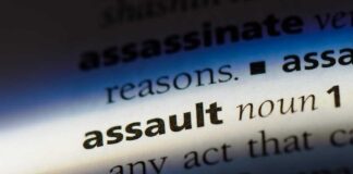 Close-up of a dictionary page showing the definition of the word assault
