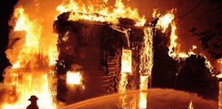 Deadly Resort Blaze – Dozens Perish in Horror A firefighter battling a large house fire at night