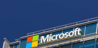 TRAPPED: Microsoft Eliminates Last Privacy Escape Route Microsoft logo on a modern corporate building against a blue sky