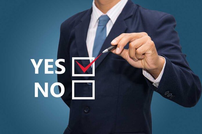Business professional indicating a yes choice with a pen