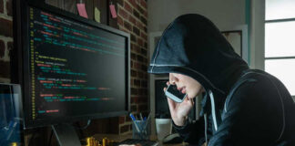 US Identity Theft Funds The UNTHINKABLE Hacker in hood using computer and phone analyzing code