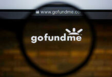 Magnifying glass over GoFundMe website logo.