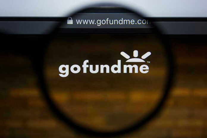 Magnifying glass over GoFundMe website logo.