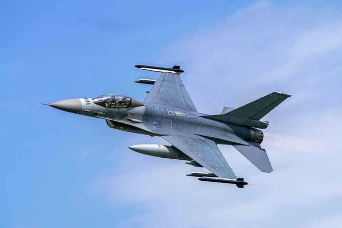 Jet fighter flying through clear blue sky.