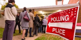 Massive Disconnect Nobody Saw Coming—ICE Dilemma People waiting in line at a polling place with a sign indicating direction