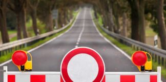 Israel BLOCKS Weak Iran Deal–Missiles Still Armed Traffic barrier with a red and white sign blocking a road