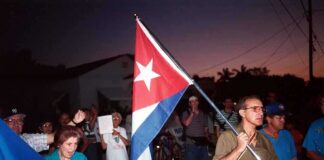UNPRECEDENTED: Trump Starves Cuba Into Submission A group of people participating in a protest march holding a Cuban flag