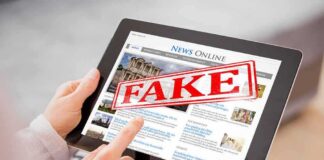 Viral “Hidden Law” Claim Targets Trump Person holding a tablet displaying a news website with a 'FAKE' stamp