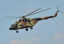 Pentagon Bet: Cold War Weapons Reborn Camouflage military helicopter in flight against blue sky.