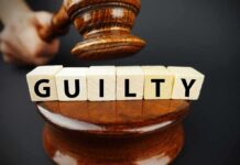 A gavel above wooden blocks spelling 'GUILTY'